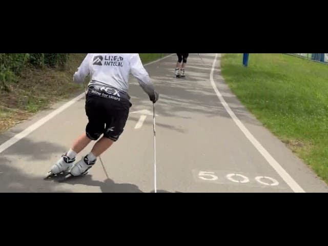 Tre uomini con magliette bianche e caschi praticano ski-roll su un sentiero asfaltato alberato.