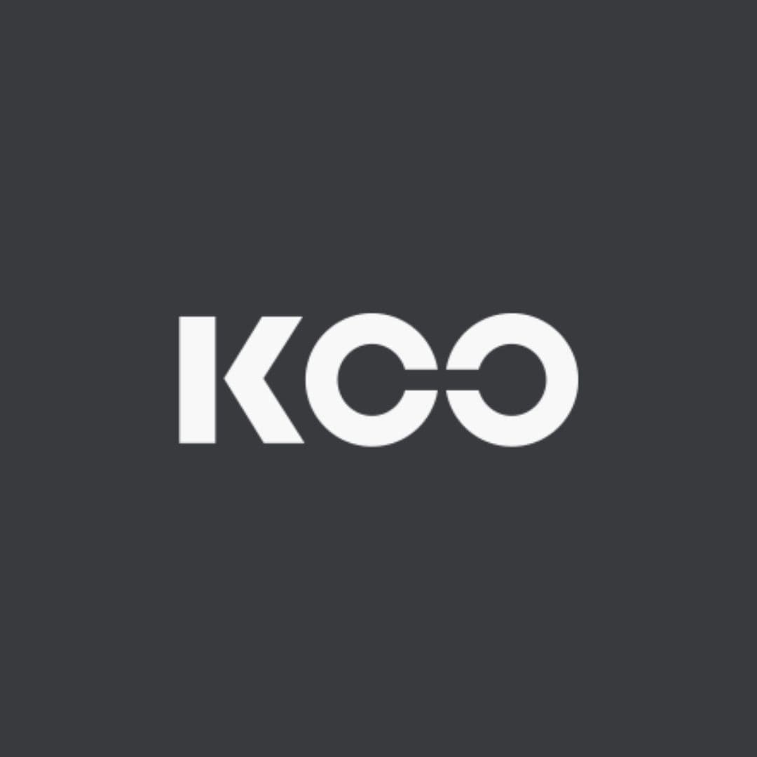 Logo KCO bianco su sfondo grigio scuro con le lettere C e O collegate.