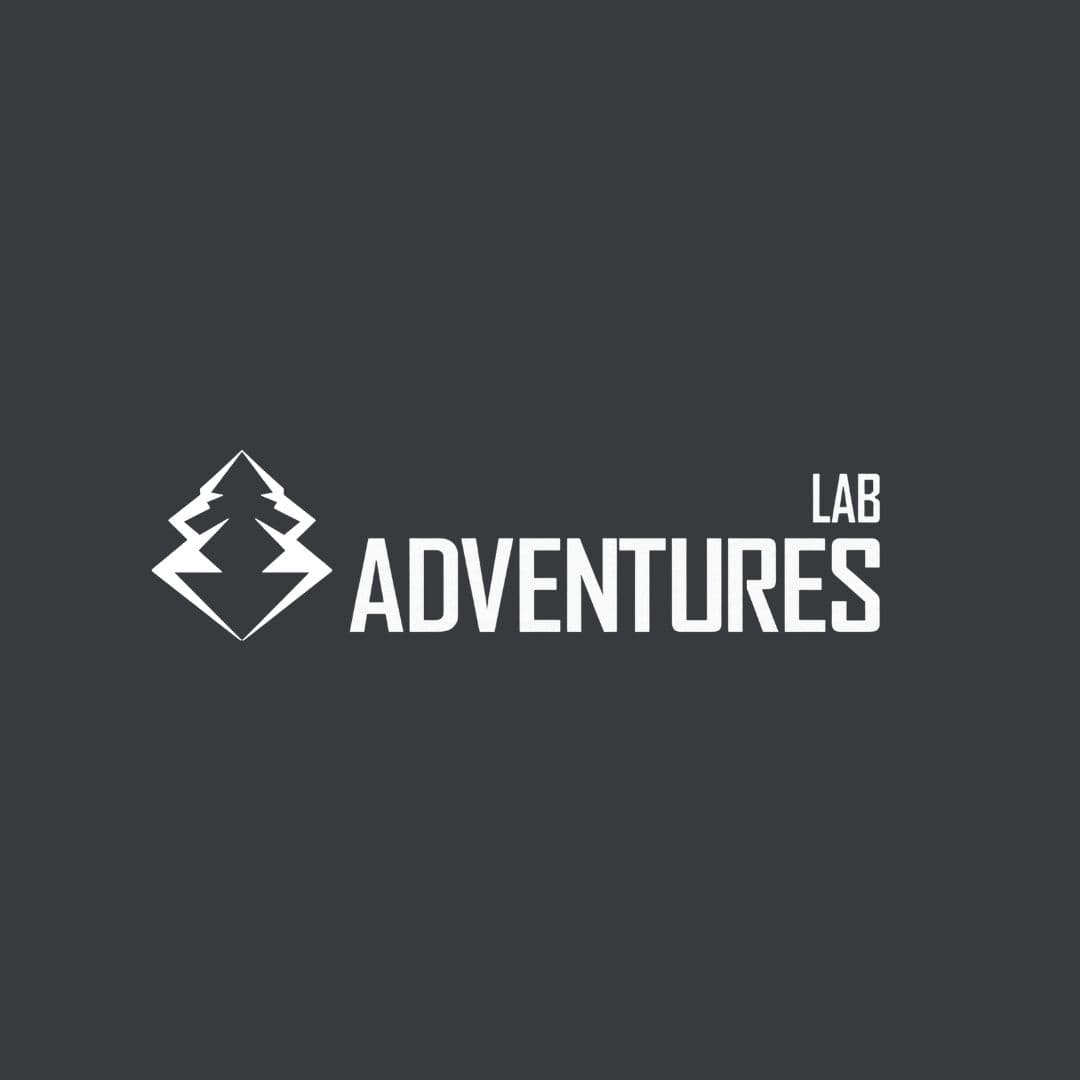 Logo bianco con pino stilizzato in diamante e scritta LAB ADVENTURES su sfondo scuro.